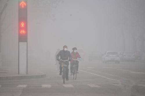 2016年2月12日，山东多地遭遇雾霾天气。市民在大雾笼罩下的山东省聊城市街头骑行。 图片来源：视觉中国