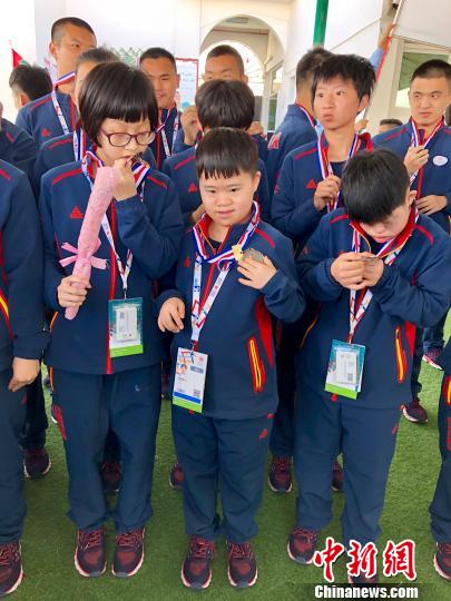 中国特奥队员们对提前得到的“奖牌”爱不释手。 王祖敏 摄