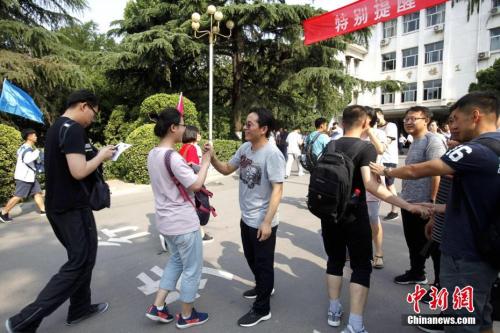 资料图：2018年6月7日，山东省实验中学考点，考生们陆续走进考场，老师为考生们加油鼓劲。<a target='_blank' href='http://www.chinanews.com/'>中新社</a>记者 王占波 摄